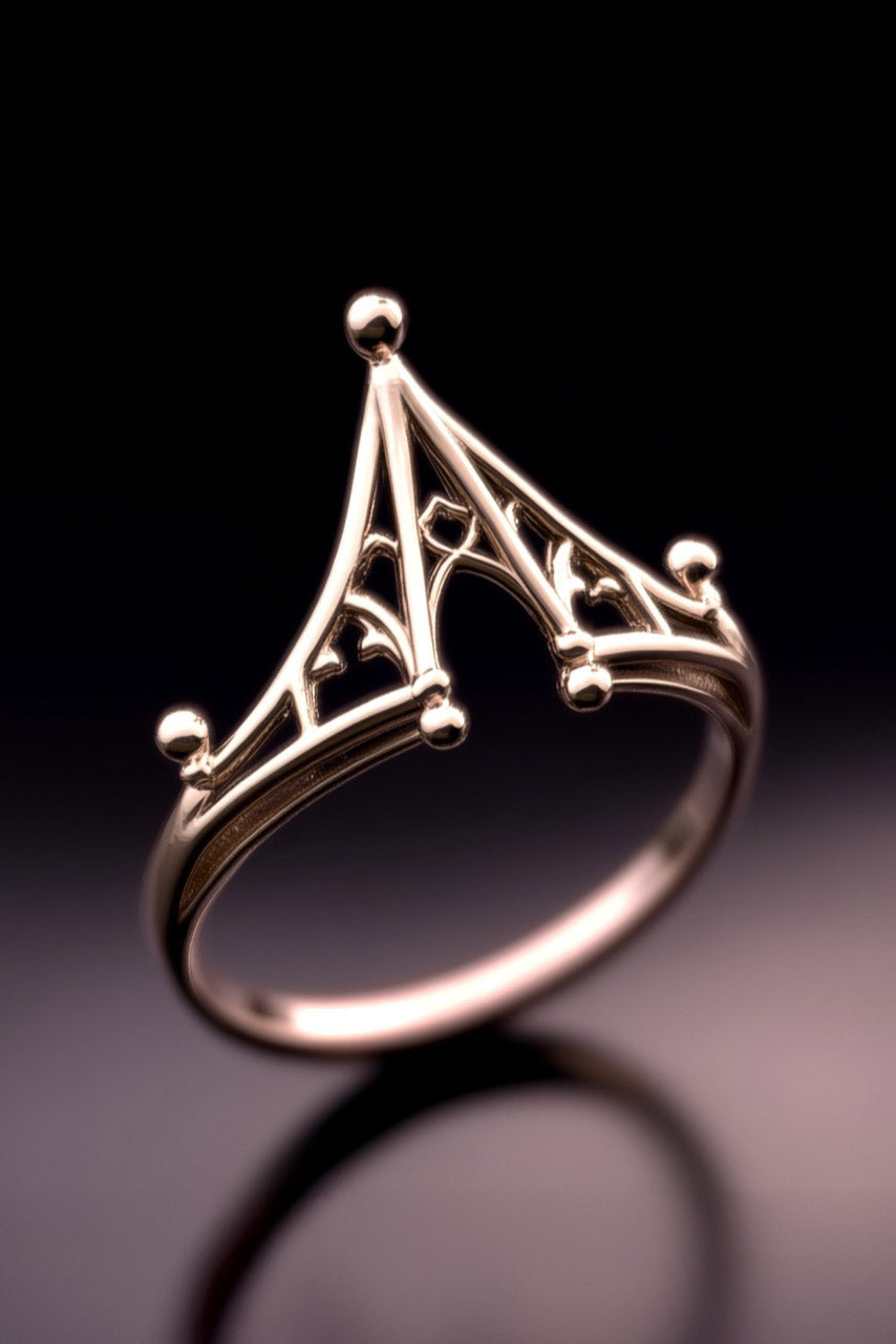 Gold ring with intricate design on a dark background