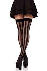 Black fishnet stockings worn with a black skirt and high heels on a white background