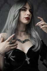large bat necklace worn by a goth woman with silver hair