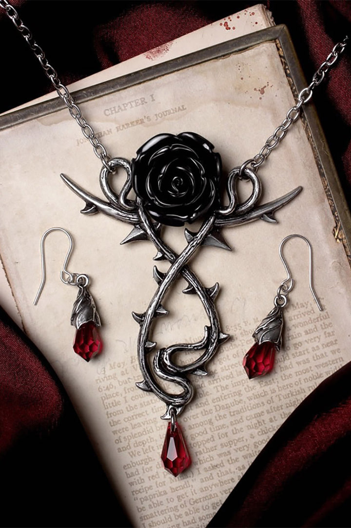 Gothic-style jewelry set with rose design on an old book