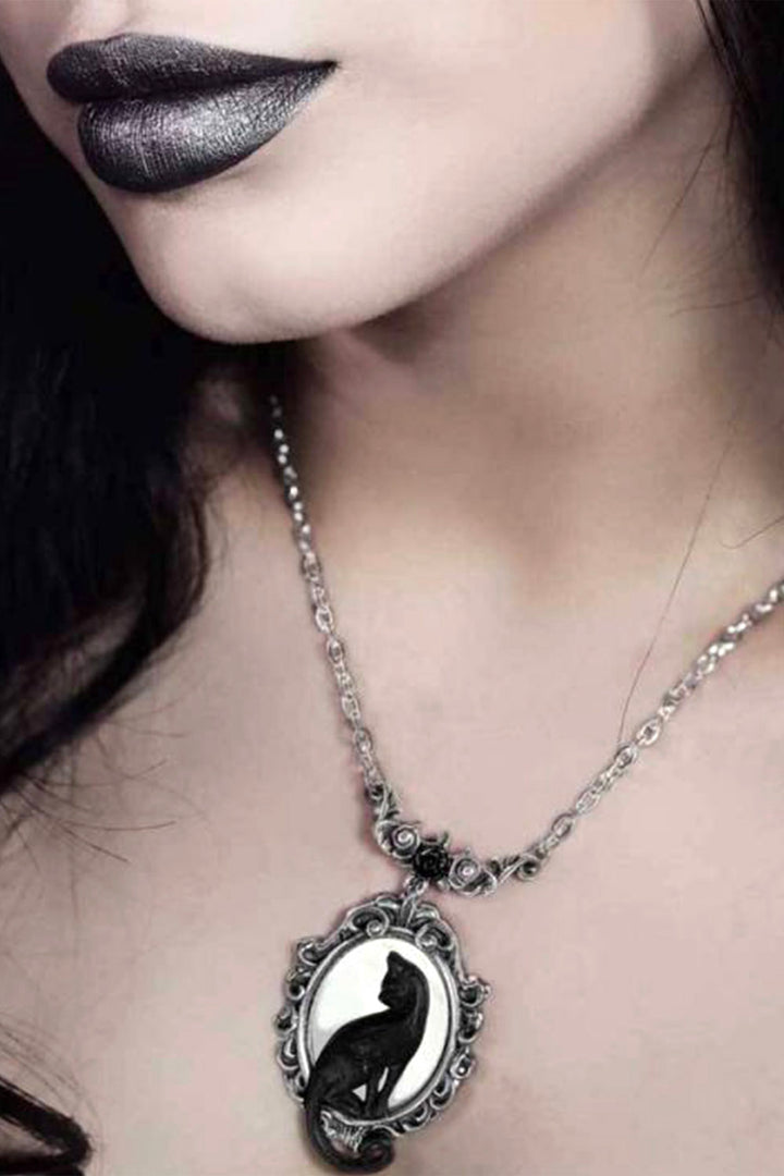 Close-up of a necklace with a black and white pendant worn by a person.
