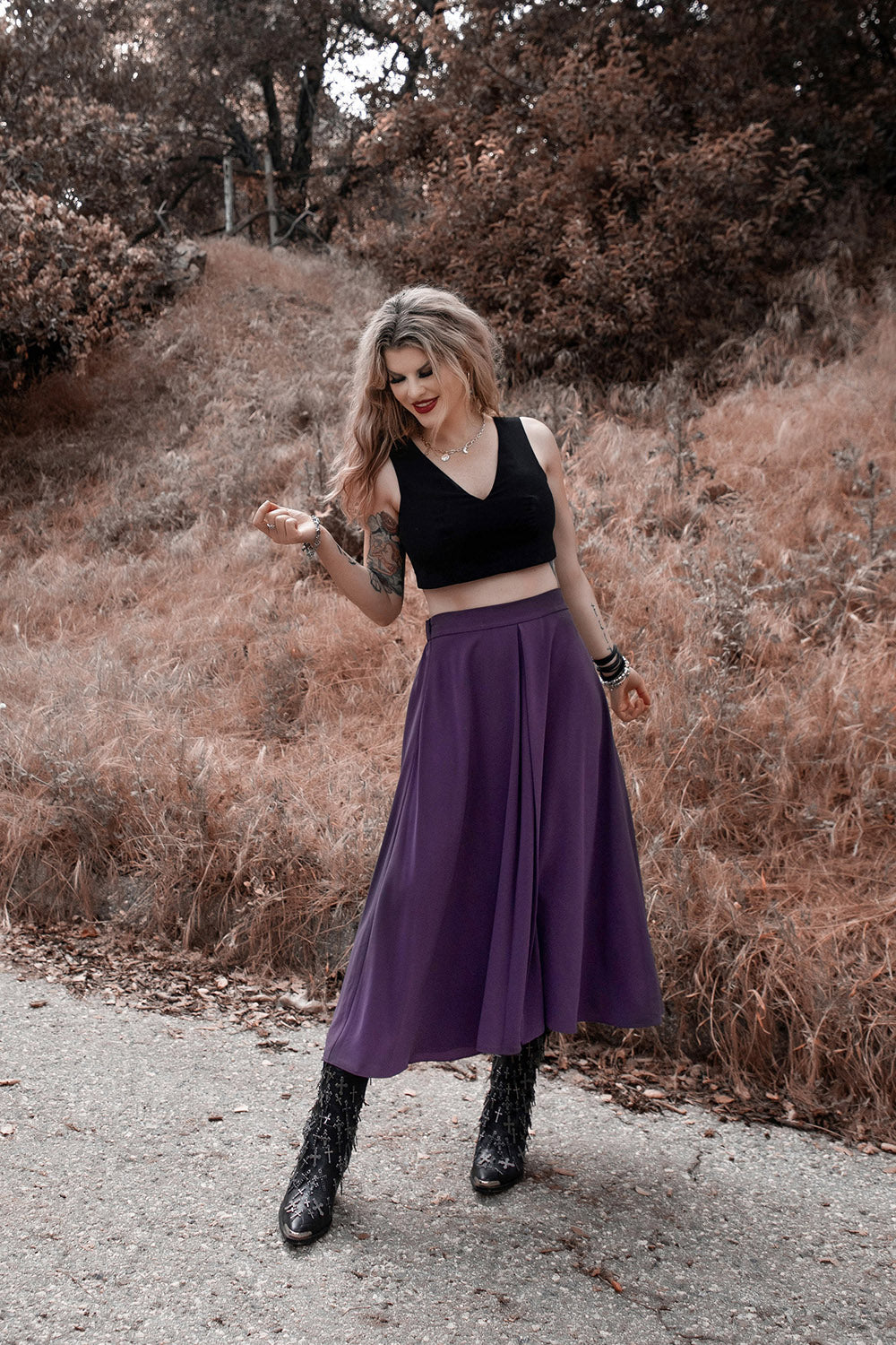 woman wearing a high-waisted flowing purple midi length skirt