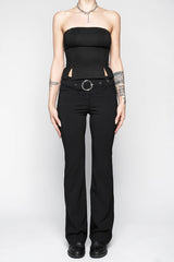 Person wearing a black strapless top and black pants on a white background