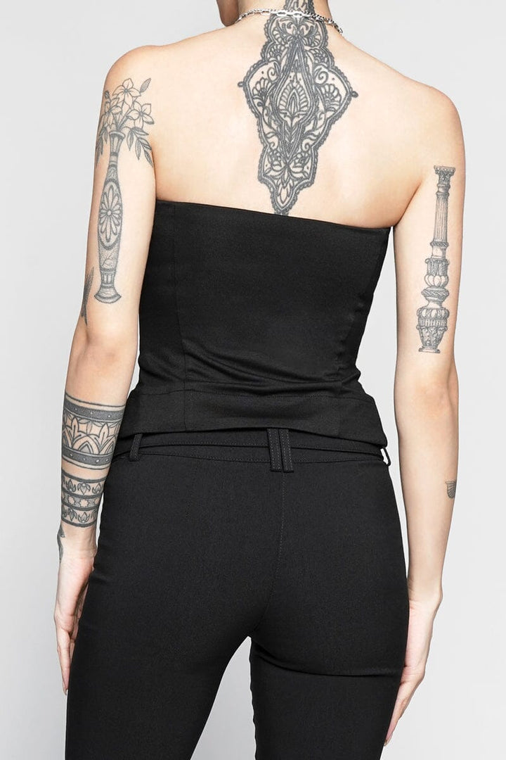 Person wearing a black strapless top and black pants with tattoos on arms and back.