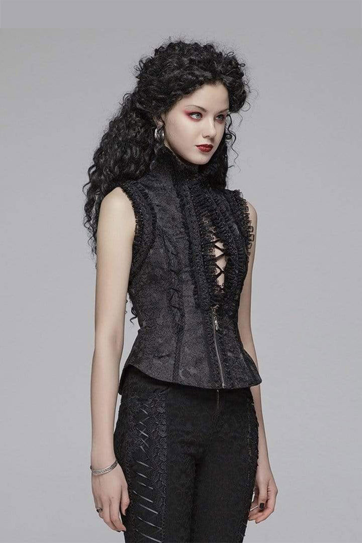 Woman wearing a dark sleeveless top with lace details on a gray background