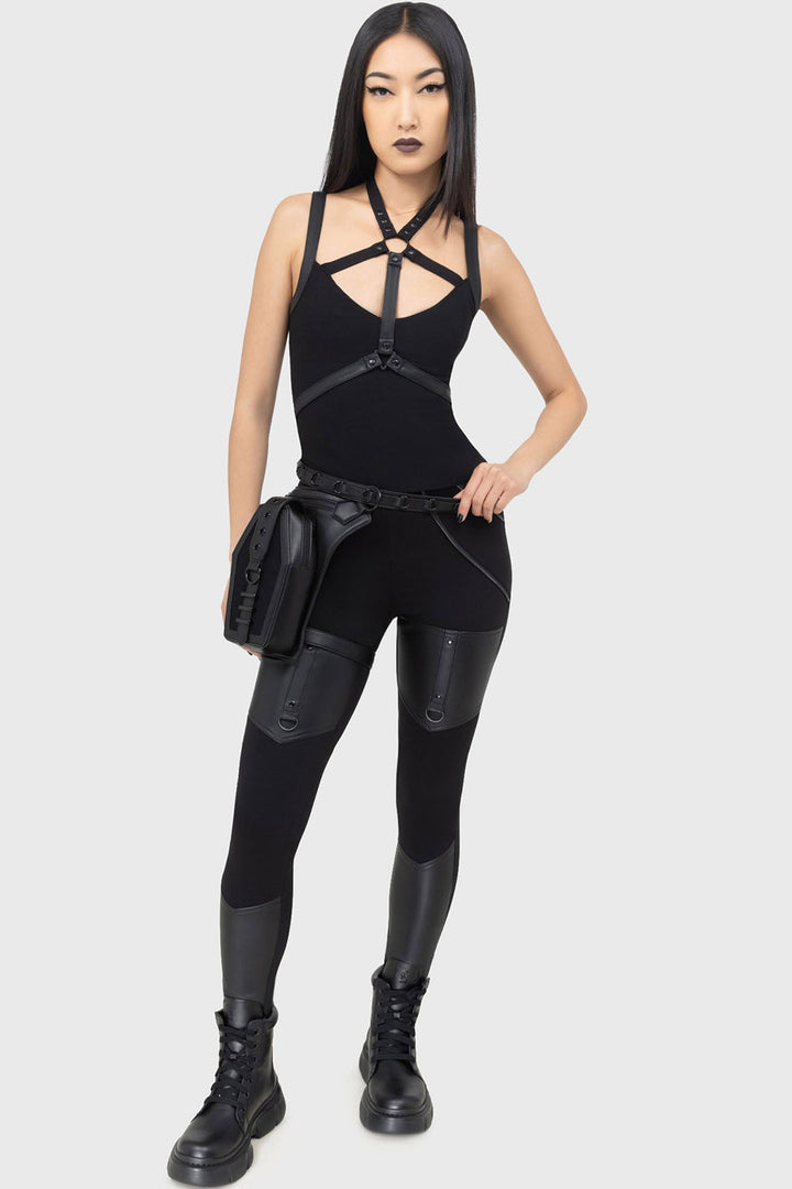 Person wearing a black outfit with gothic holster hip bag on a white background