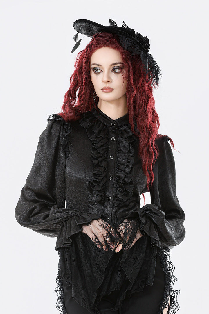 Woman wearing a black gothic outfit with ruffles and lace on a white background