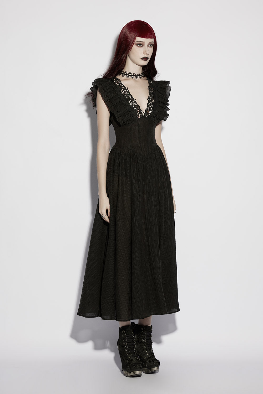Woman wearing a black dress with ruffled details on a white background