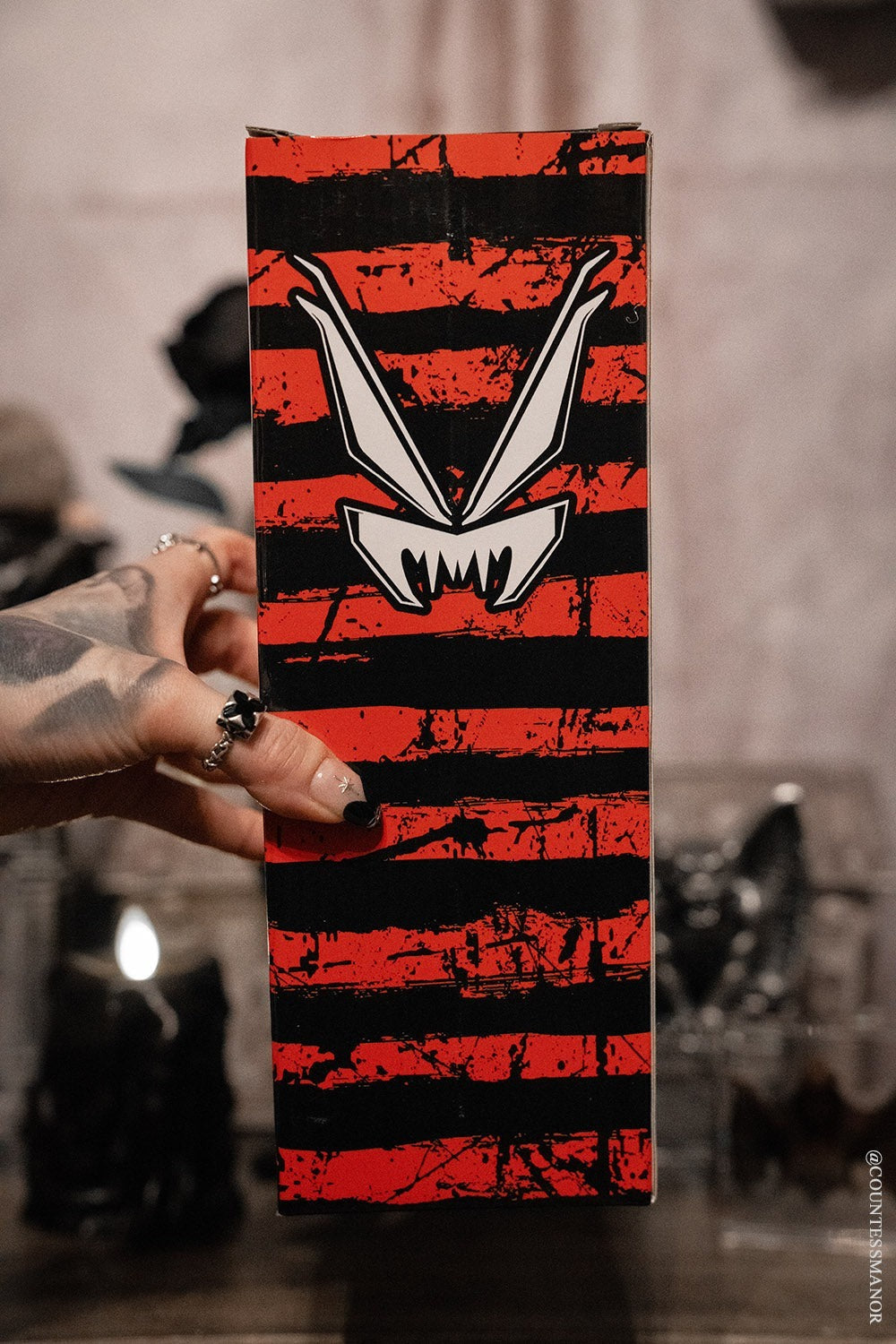 Hand holding a striped gift box for a krampus stainless steel xmas water bottle 