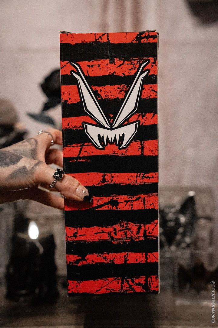Hand holding a striped gift box for a krampus stainless steel xmas water bottle 