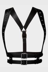Black leather harness with studded details on a light gray background