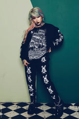 tattooed woman wearing a gothic loungewear suit 