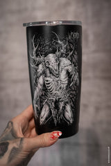 Black tumbler with a detailed skull and deer design held by a hand with red nail polish.