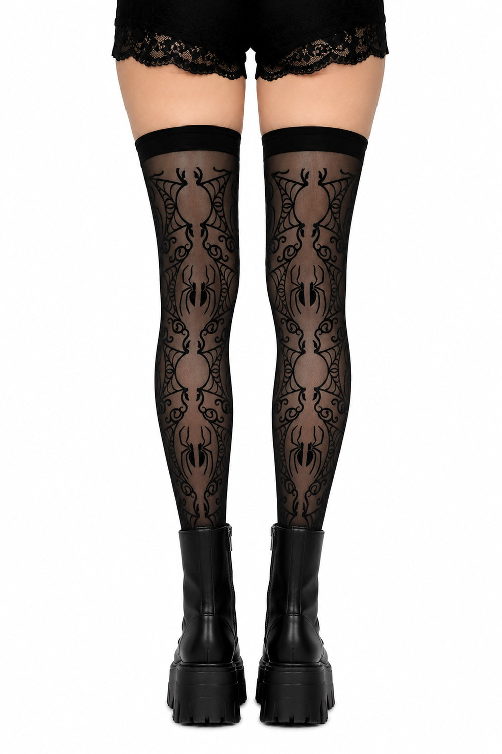 Black gothic thigh-high stockings with a repeating spider pattern, worn with black lace-up platform boots against a white background.