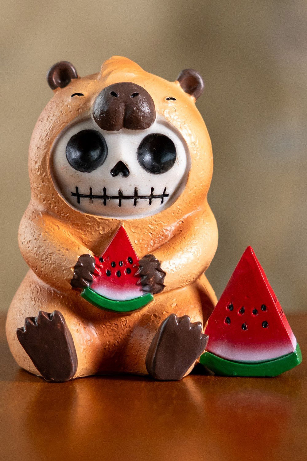 Skeleton capybara resin toy statue holding a watermelon on a white background