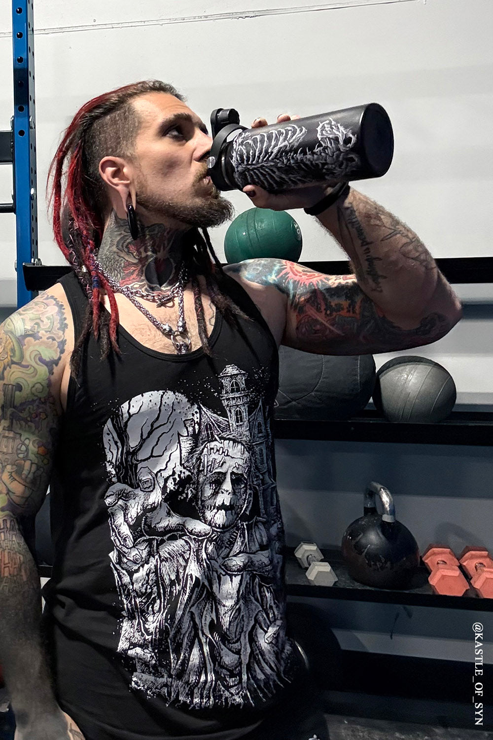 tattooed guy using skeleton stainless steel water bottle at gym