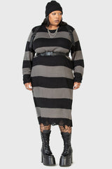 goth girl wearing a black and gray striped emo dress with a high-waisted plus size gothic belted harness and platform boots on a white background