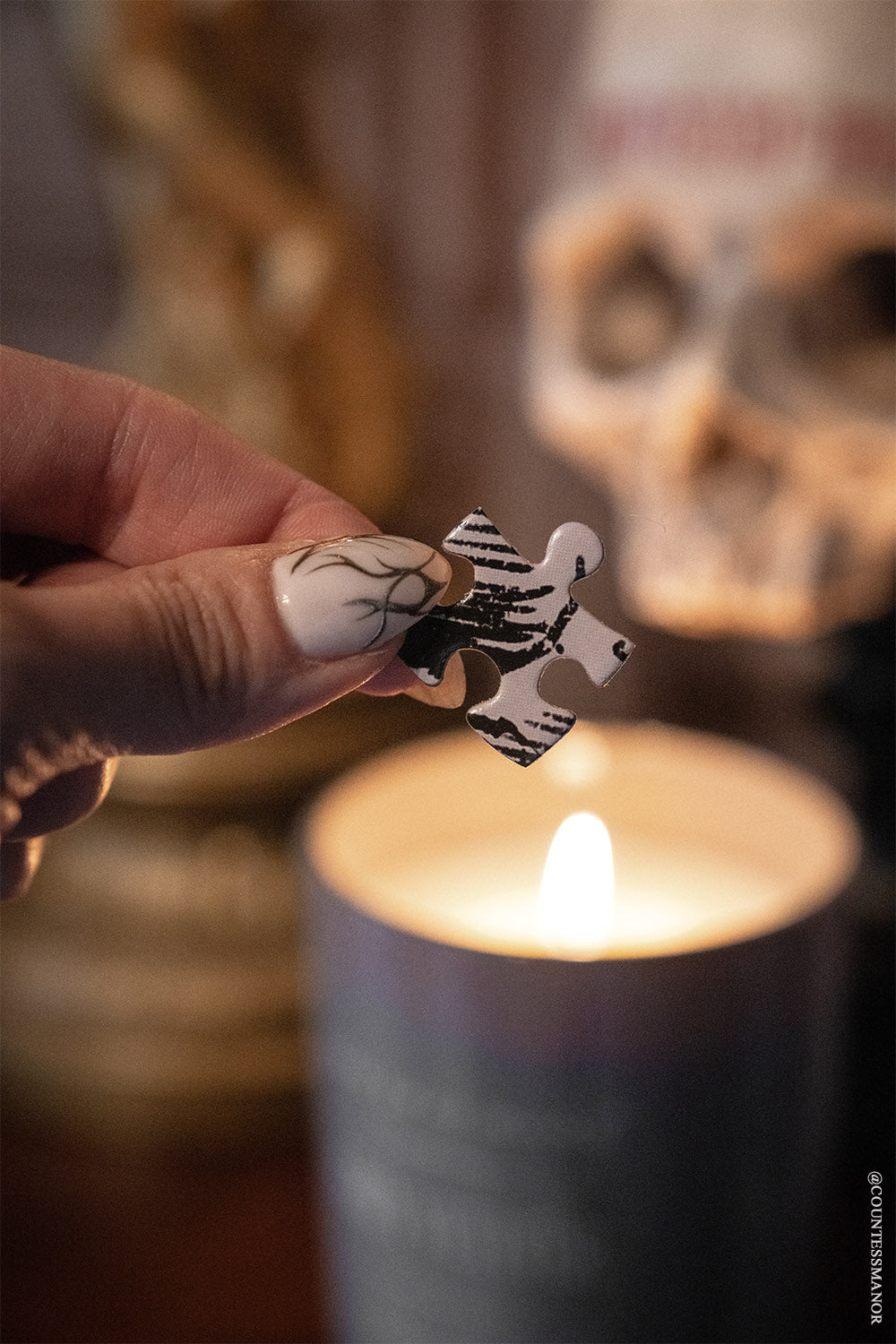 tattooed hand holding a halloween puzzle piece