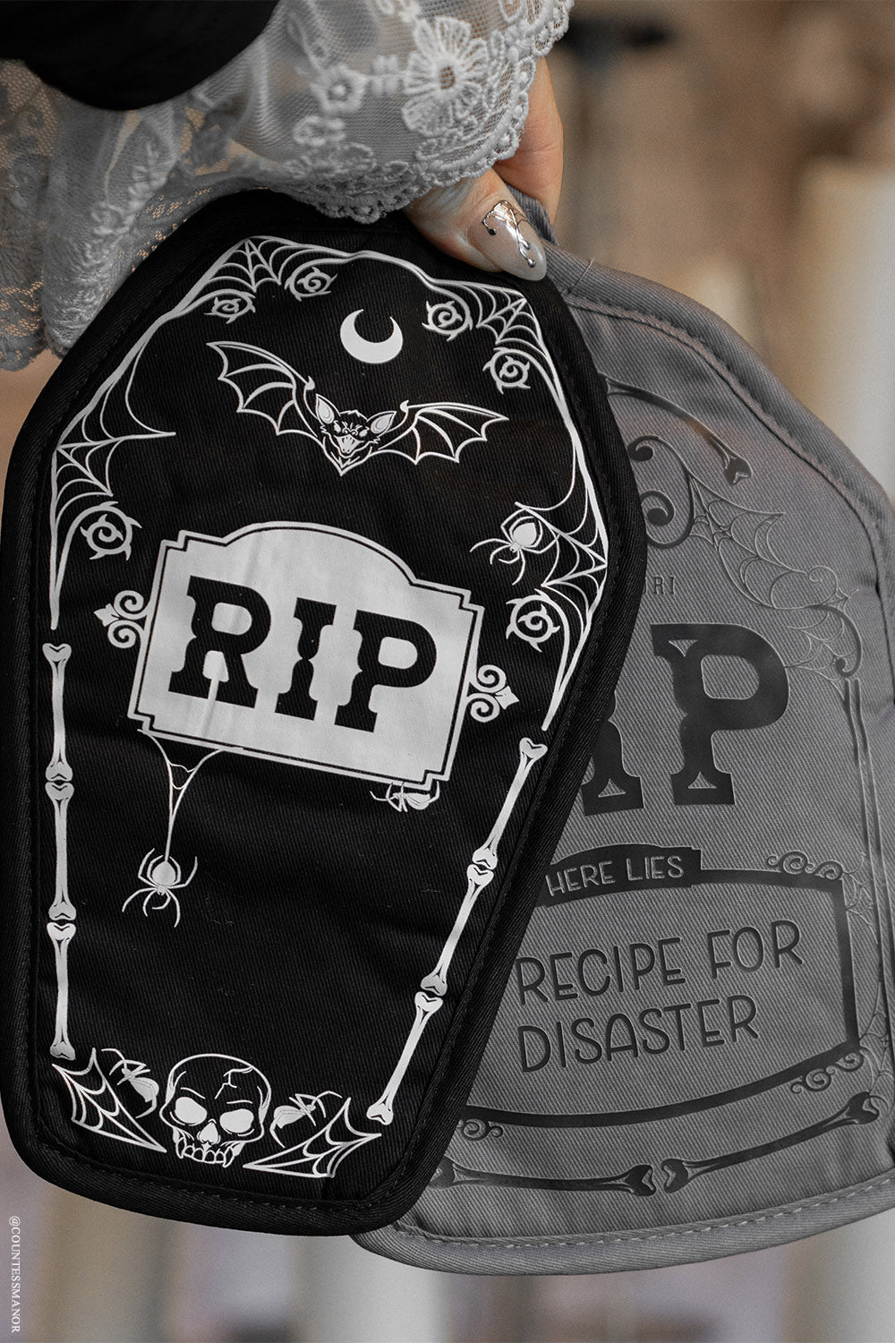Black and gray gothic pot holders with 'RIP' design and text on a blurred background