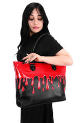 Woman holding a black and red bag with dripping blood design