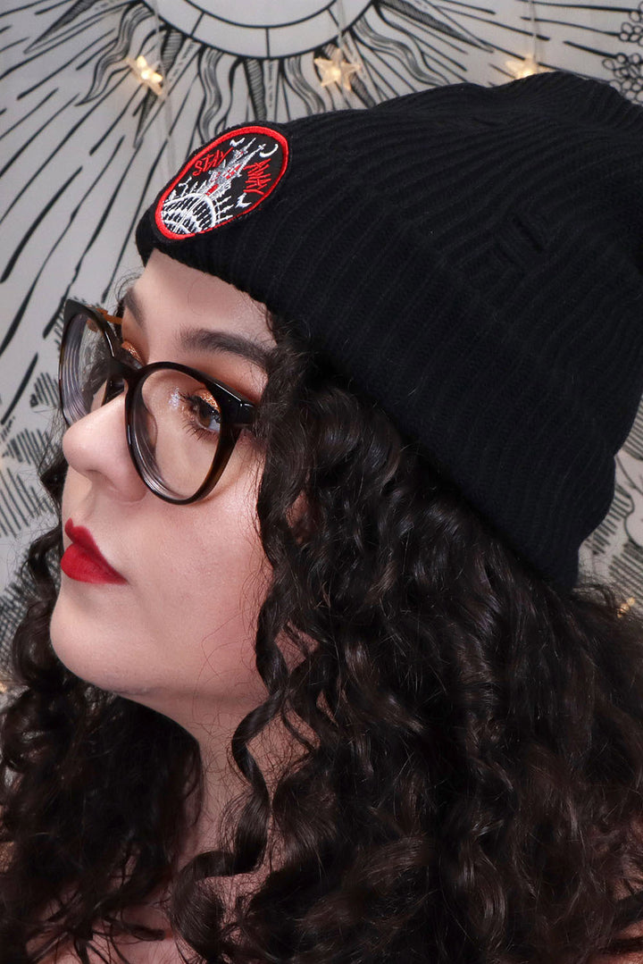 ribbed knit beanie with haunted house patch on it