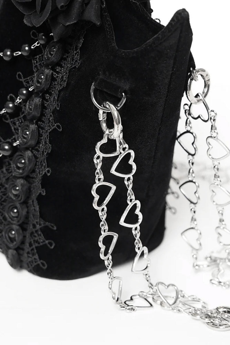 Black handbag with a heart-shaped chain detail on a white background