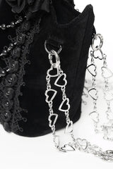Black handbag with a heart-shaped chain detail on a white background