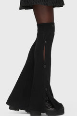 Black knit leg warmers worn by a person on a white background