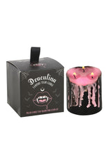 Vampire-themed candle with pink wax and black base, next to its packaging box.