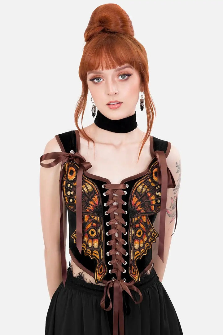 Woman wearing a detailed black and brown corset with decorative elements on a white background