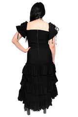 Black ruffled dress worn by a person on a white background