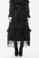 Person wearing a black gothic-style dress with lace details on a white background
