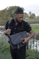 Alternative gothic shoulder bag with black studded hardware buckle straps and multiple storage pockets for emo punk grunge and dark aesthetic fashion