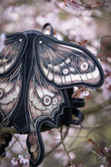Moth backpack with shield-shaped base made of black faux suede