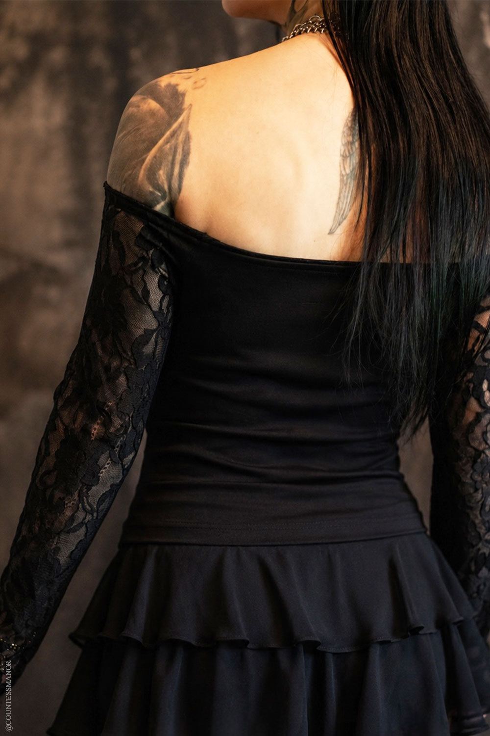 Model wearing off shoulder black top with lace sleeves from VampireFreaks