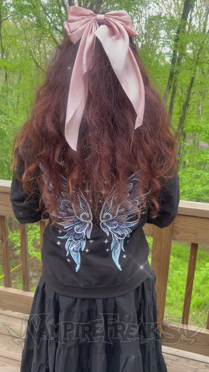 video of a woman wearing a lunar moth hoodie with fairy wings on the back 
