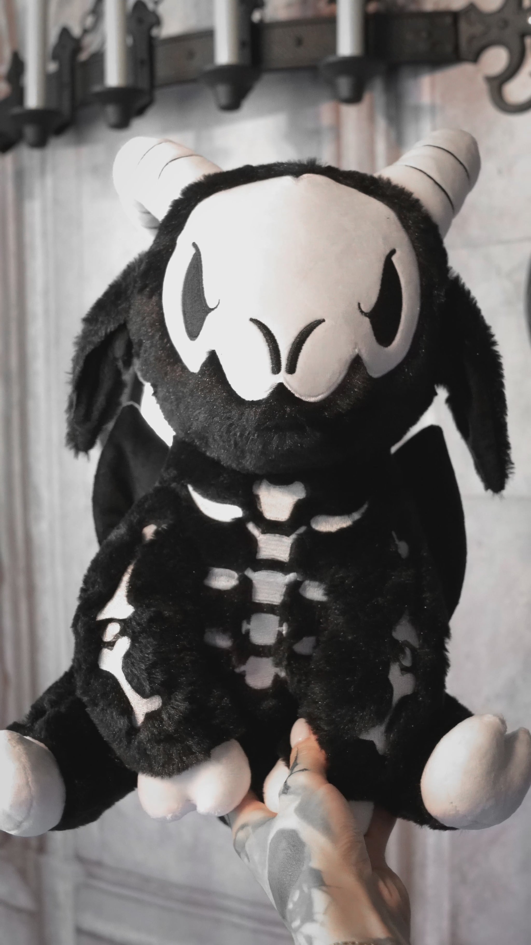video of a large spooky black embroidered goat skeleton stuffed animal plushie
