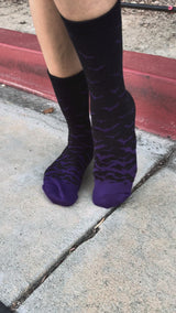 Video of woman wearing black socks with purple bats