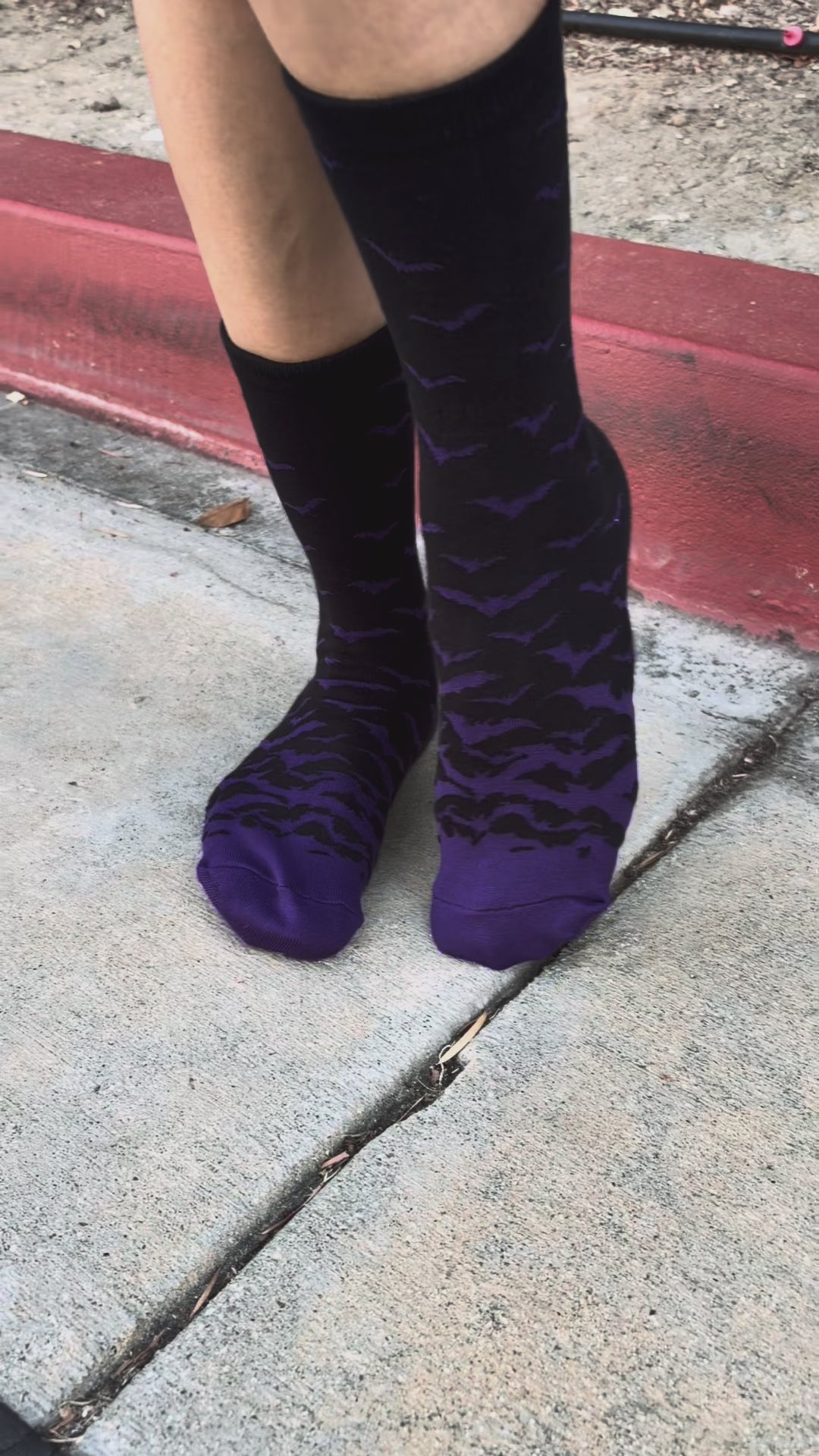 Video of woman wearing black socks with purple bats