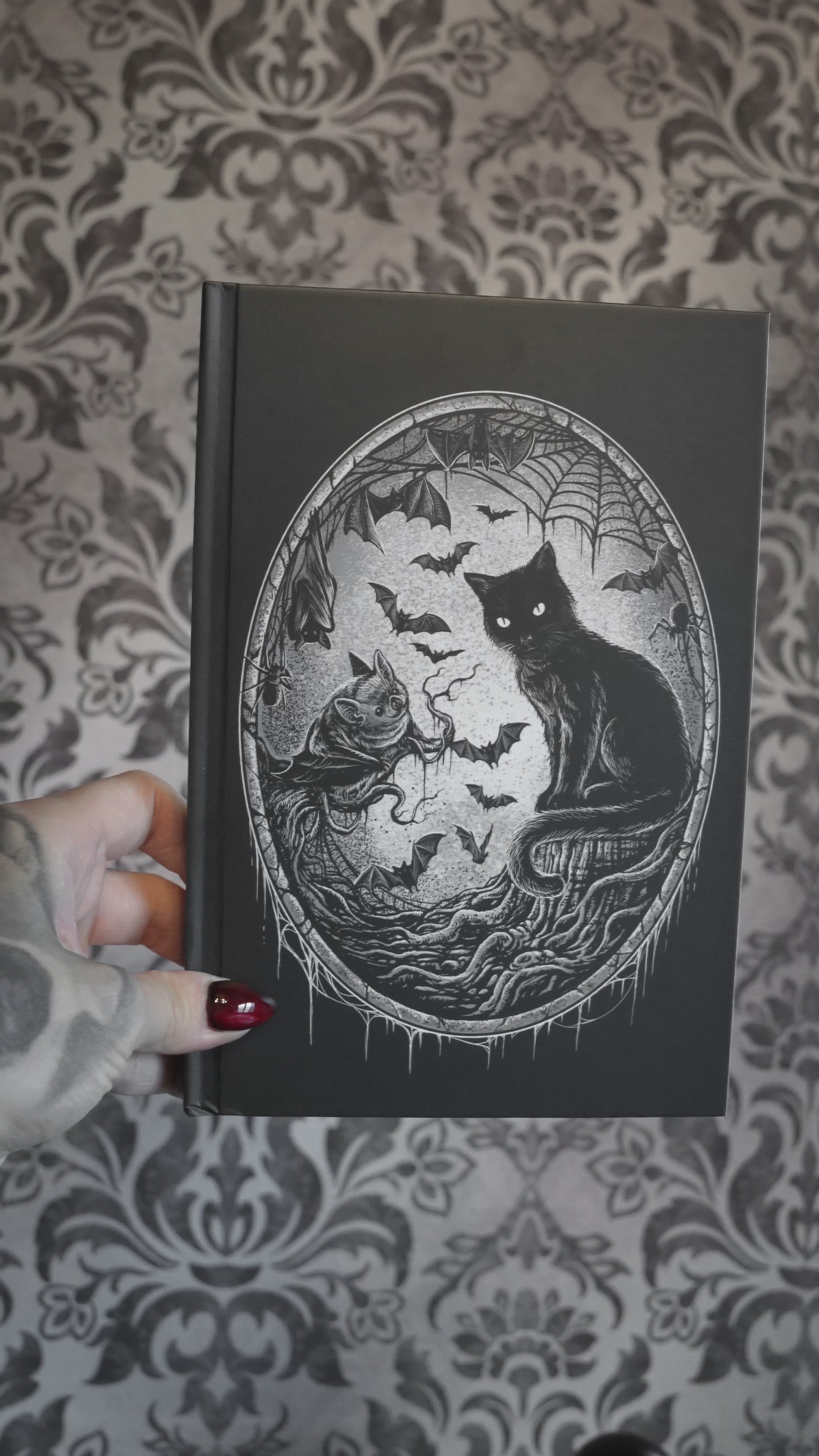 video of a gothic notebook with spiderweb pages inside 