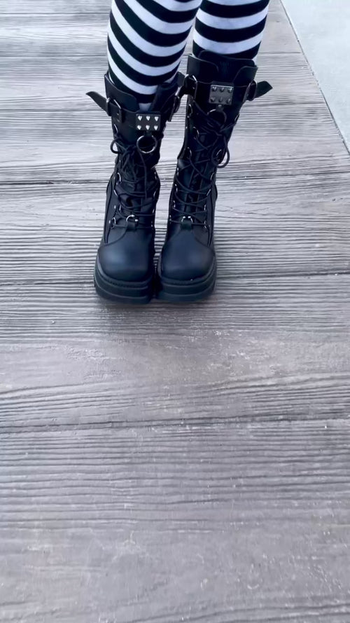 video of a goth woman wearing a black cotton oversized creepy alice in wonderland sweater