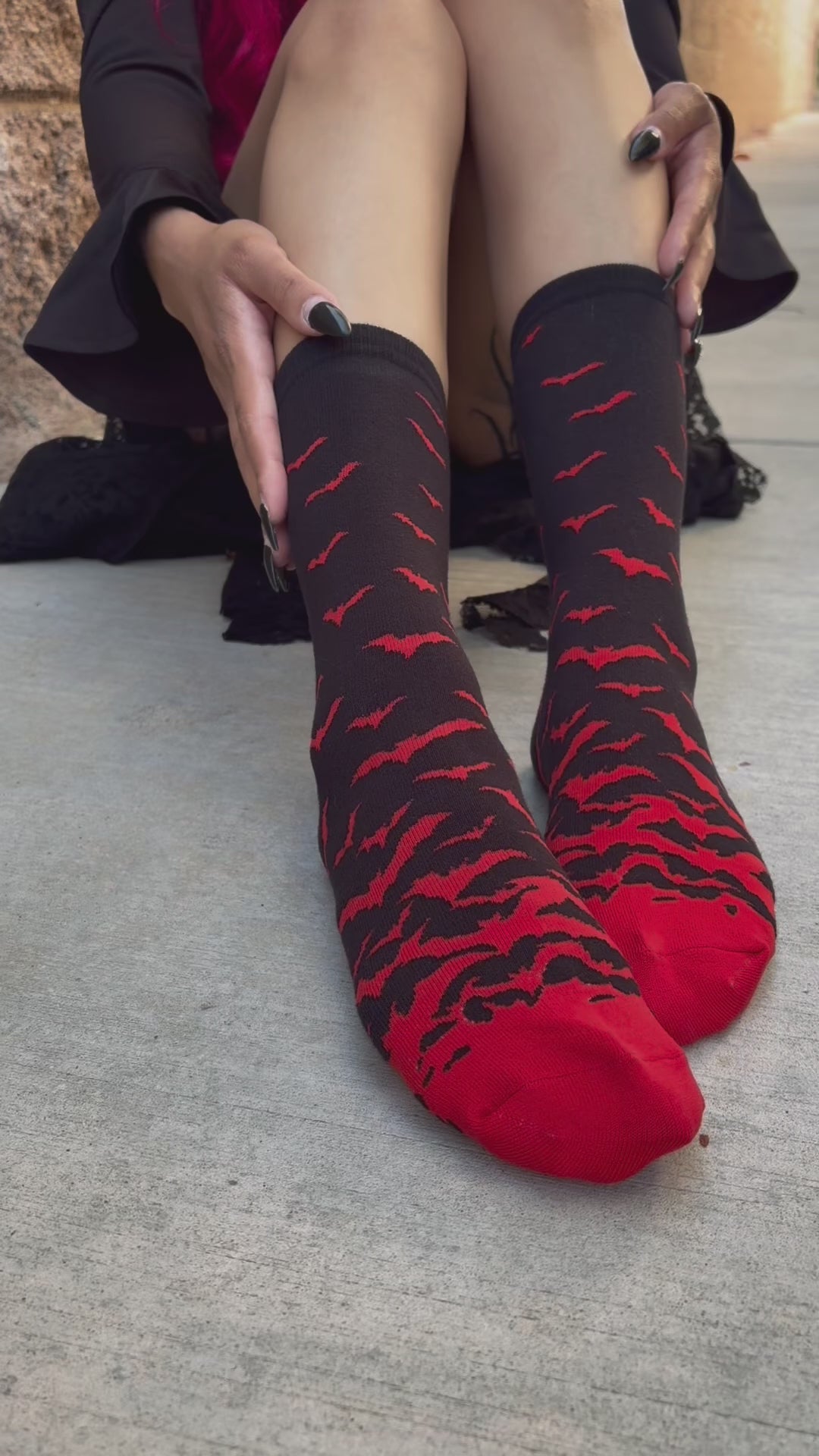 gothic woman wearing halloween vampire black and red bat socks