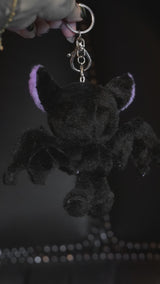 video of a purple and black skeleton bat keychain