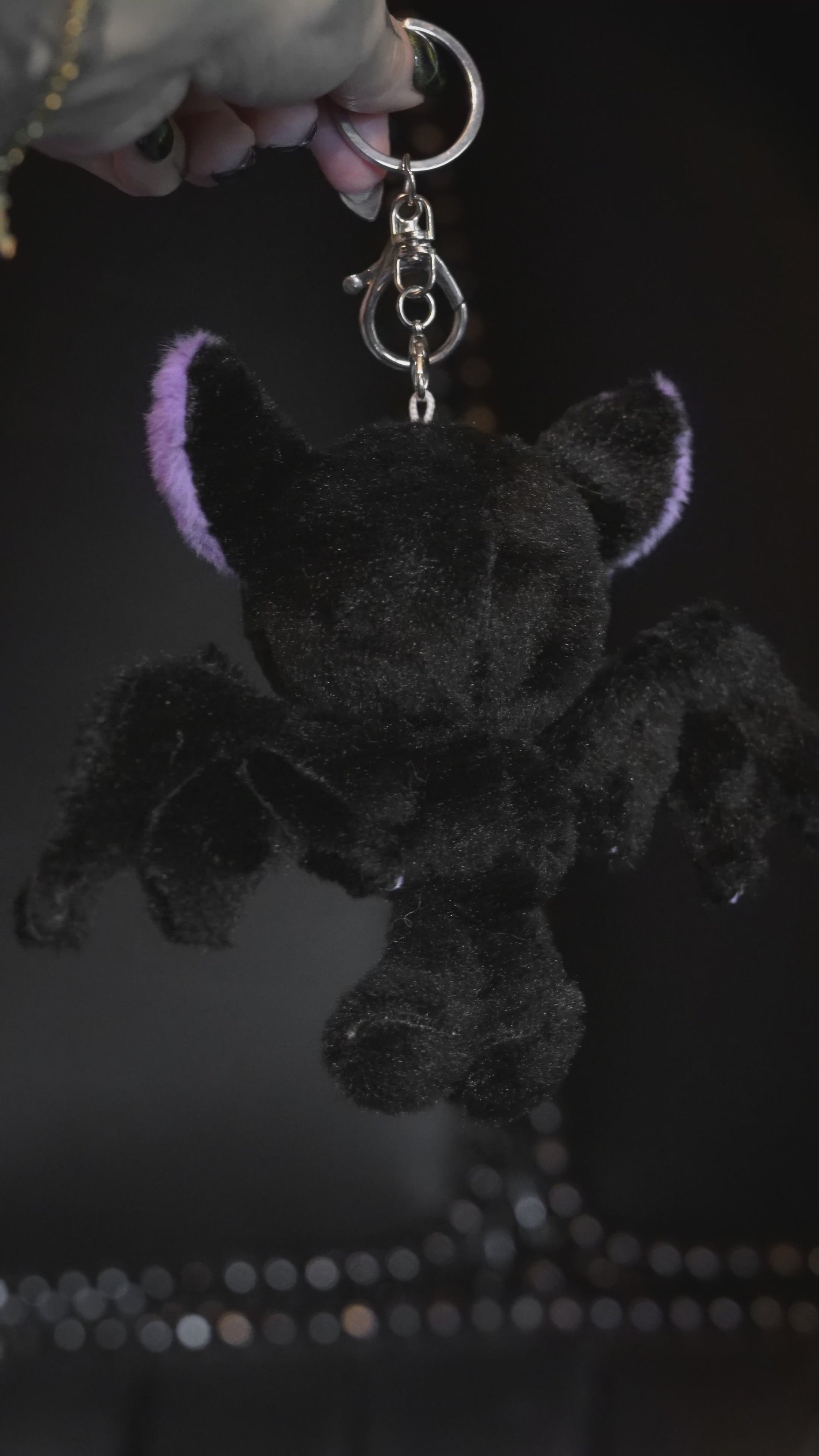 video of a purple and black skeleton bat keychain