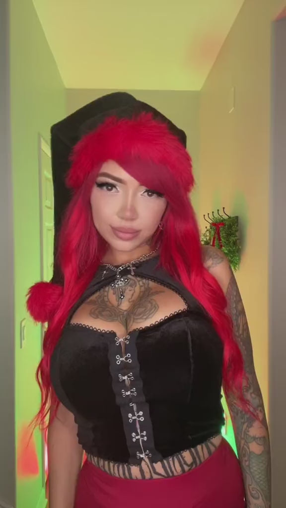 goth women wearing a emo santa clause hat