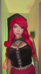 goth women wearing a emo santa clause hat