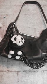 video of a stuffed animal black and white skeleton pig keychain
