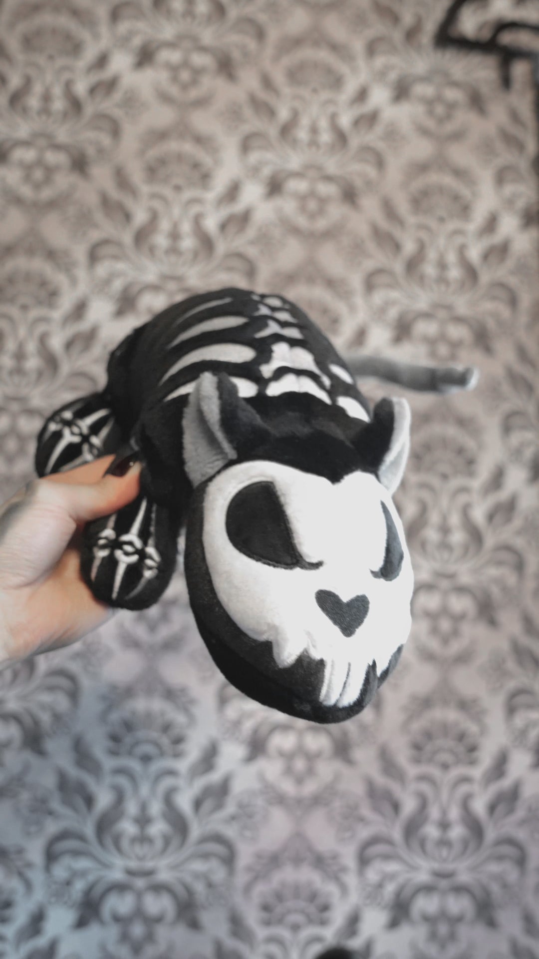 video of a gothic skeleton rat plushie