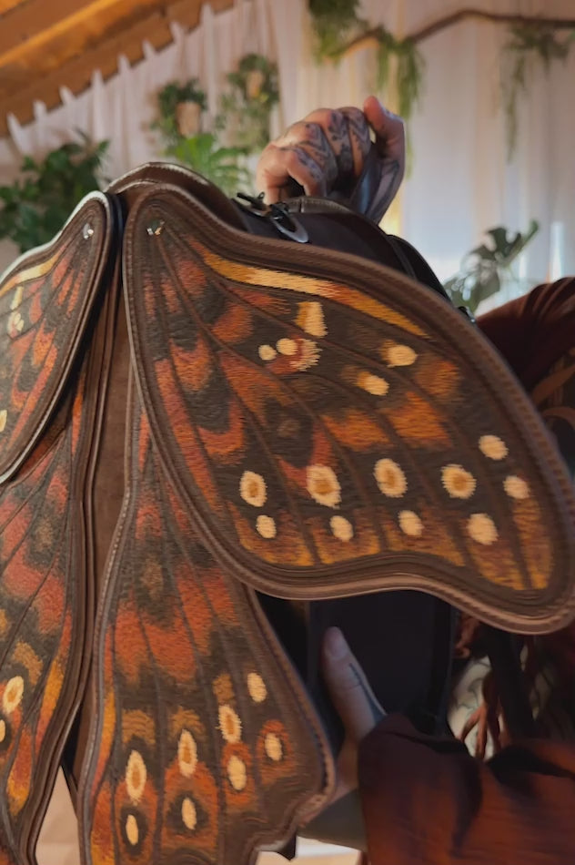video of a whimsical embroidered moth wings backpack