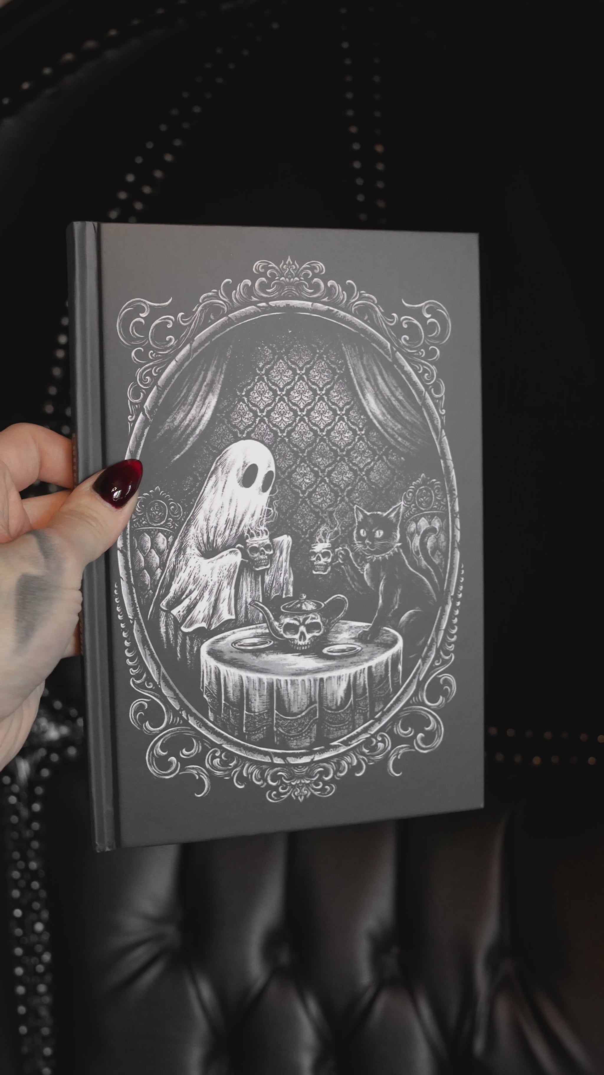 video of a spooky hardcover ghost and black cat diary 